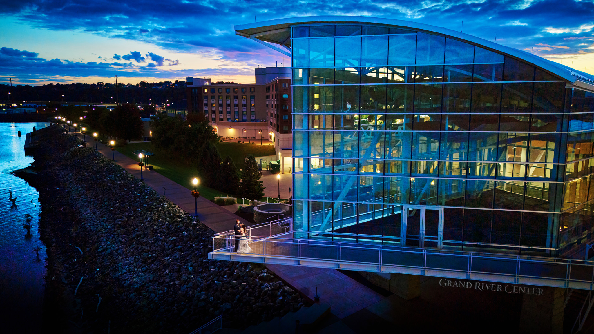 Aerial view of the Grand River Center at dusk with bride and groom on the balcony in Dubuque, Iowa